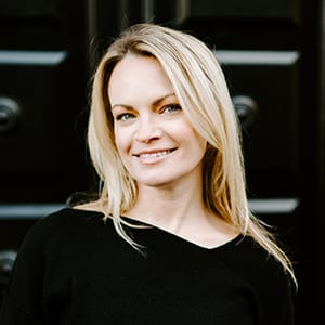 Individual named Erin Harmon sporting long blond hair and wearing a black shirt.